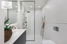 Przestronna łazienka w szarościach. Komfortowy prysznic i pojemne szafy w mieszkaniu na sprzedaż w Krakowie.